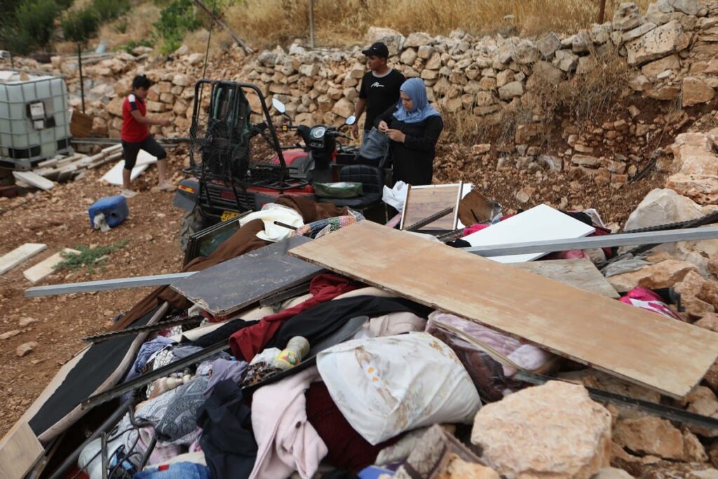 فلسطينيون على أنقاض منزلهم الذي دمره الاحتلال في الضفة الغربية